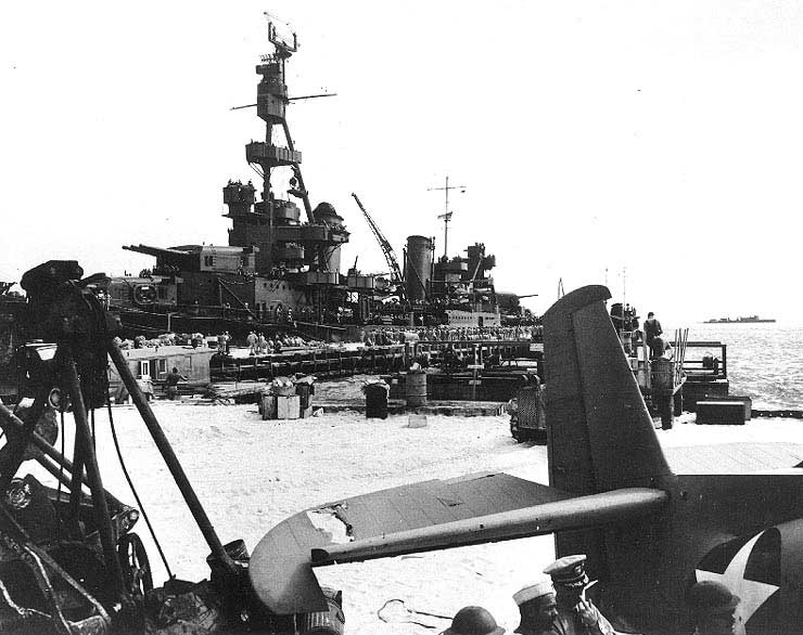 Pensacola at Sand Island, Midway Atoll, disembarking Marine reinforcements, 25 Jun 1942; at the foreground was the lone surviving land-based Avenger of Midway battle