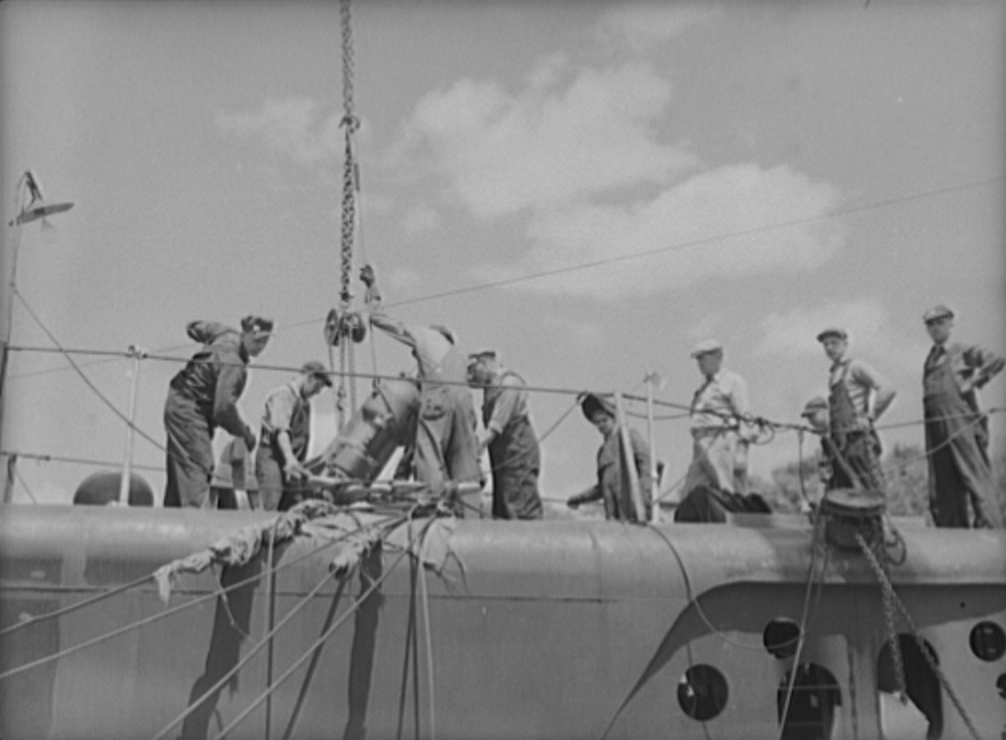 Shipyard workers installing engine parts onto a submarine, possibly the future USS Puffer, at Manitowoc, Wisconsin, United States, Aug 1942, photo 1 of 2