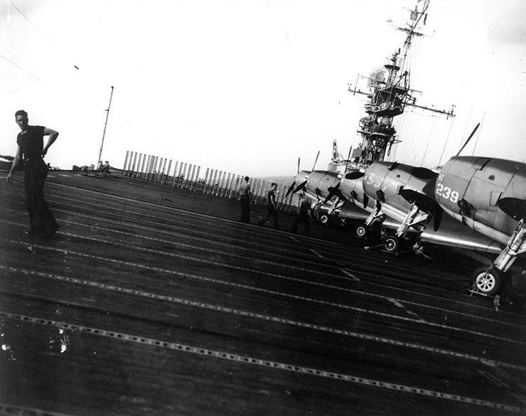 San Jacinto rolling heavily and pitching in rough seas while en route to attack Okinawa, 6 Oct 1944; note parked TBM Avenger aircraft of VT-51 on the flight deck