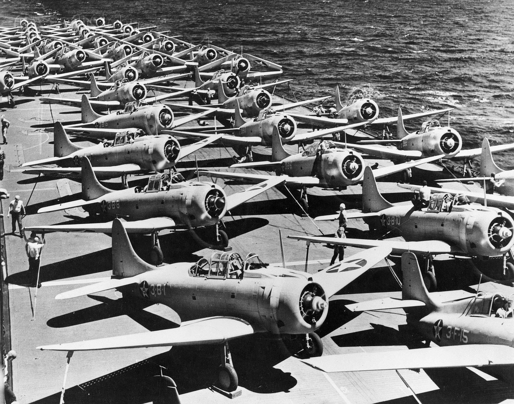 F4F-3 Wildcat (foreground), SBD-3 Dauntless (center forward and background), and TBD-1 Devastator (center rear) aircraft on the flight deck of USS Saratoga, 1941