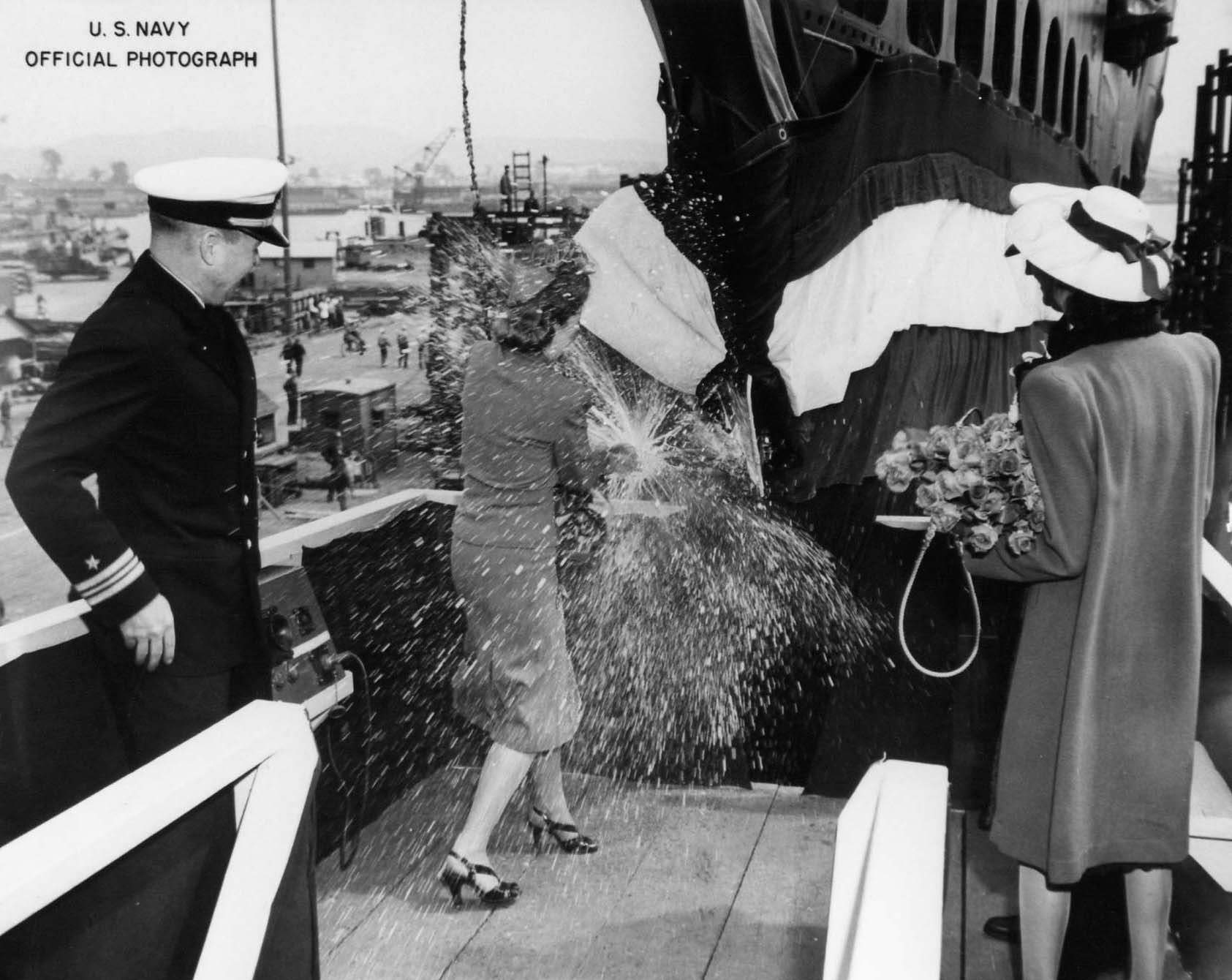 Mrs. Davenport breaking bottle on bow of submarine Trepang while his husband Commander Roy Davenport and Mrs. Garvey looked on, Mare Island Naval Shipyard, California, United States, 23 Mar 1944
