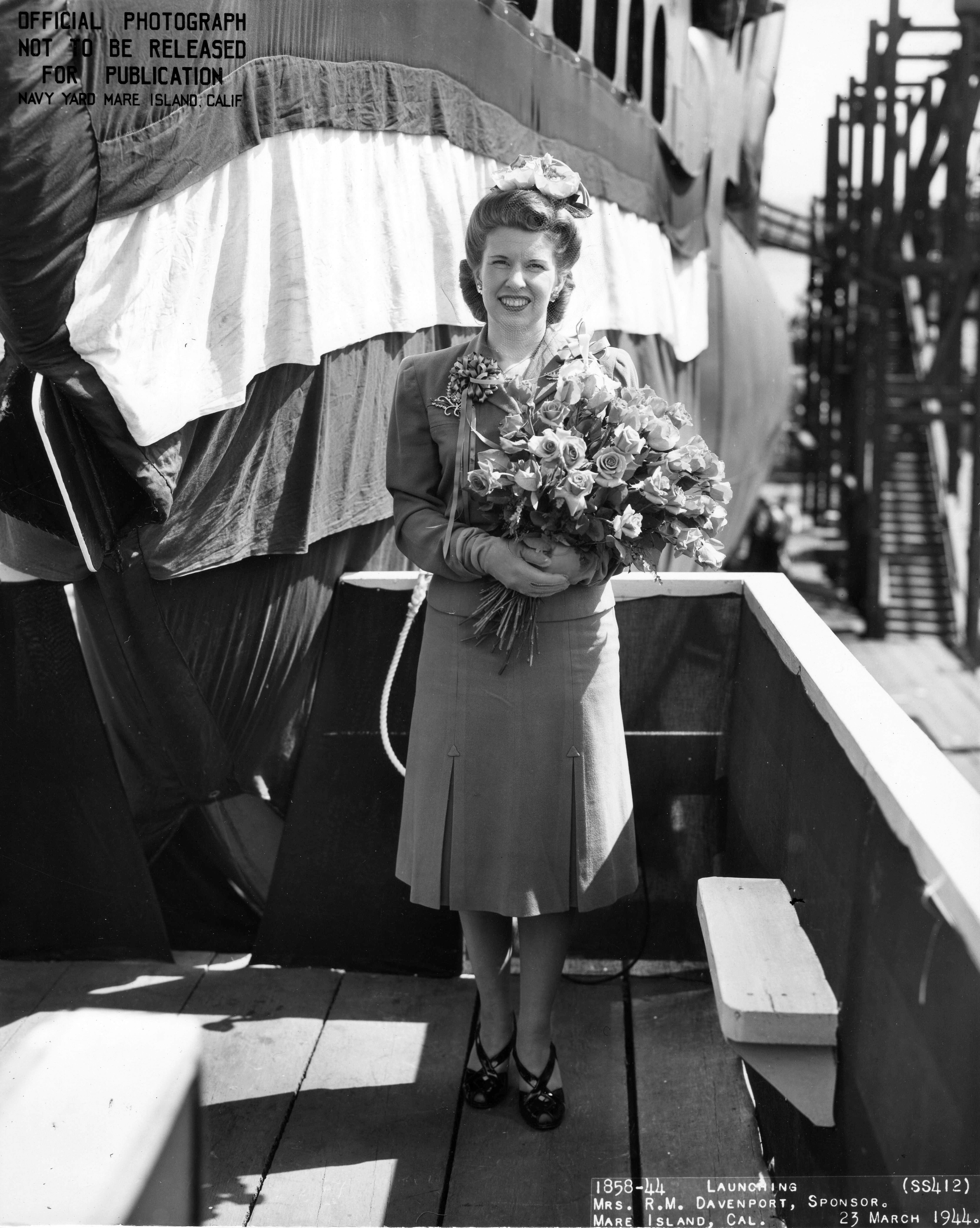 Mrs. Davenport, wife of future commanding officer of Trepang, posing with the submarine at its christening, Mare Island Naval Shipyard, California, United States, 23 Mar 1944