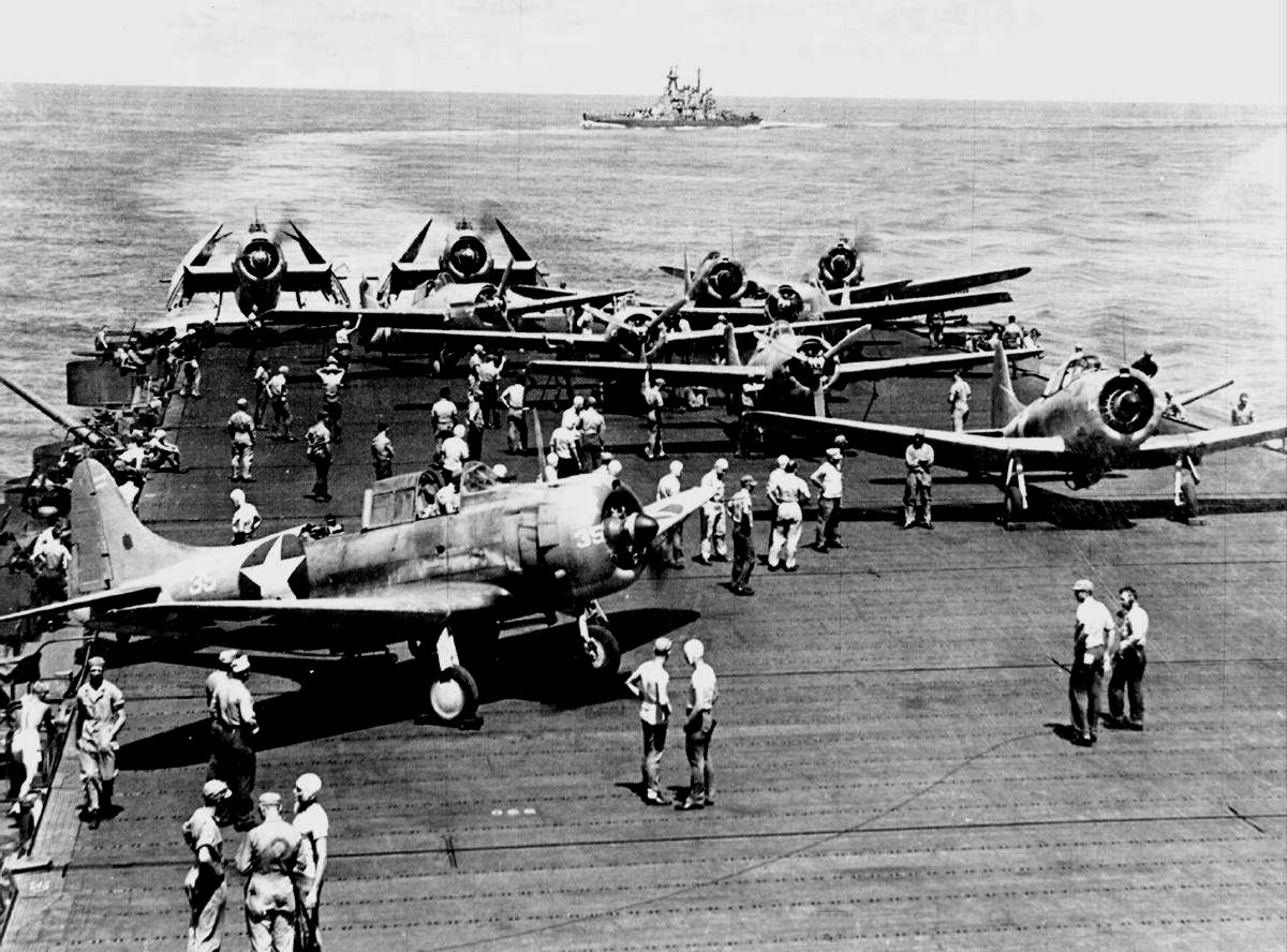 SBD-3 Dauntless, F4F-4 Wildcat, and TBF-1 Avenger aircraft aboard USS Enterprise, northeast of Nouméa, New Caledonia, 2 May 1943; note USS Washington in background