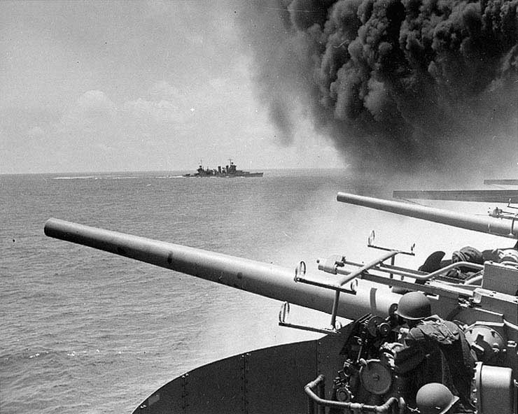 Starboard side guns of Yorktown ready to fire, 4 Jun 1942; note the smoke rising from the carrier; cruiser Astoria in background
