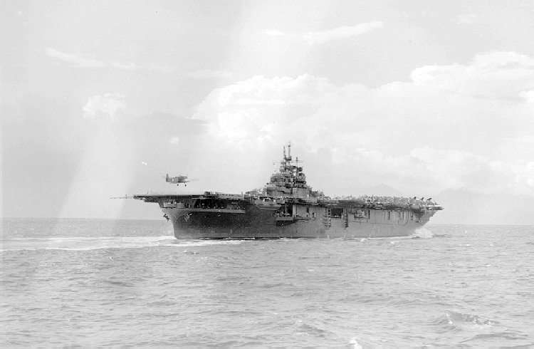 USS Yorktown moving astern while receiving a landing TBF Avenger aircraft, Jul 1943