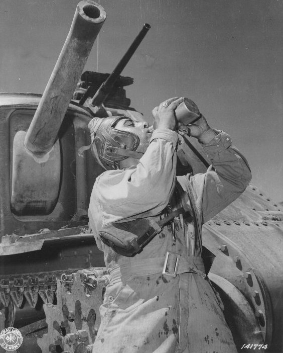 Corporal Philip Margherito of HQ Company, US 752nd Tank Battalion drinking water during a M3 medium tank training mission, Desert Training Center, Indio, California, United States, 10 Jun 1942