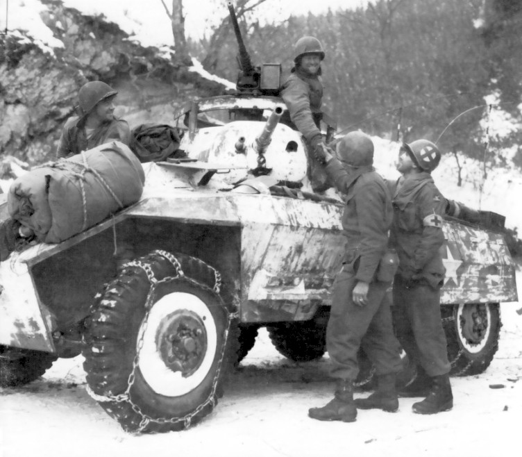 M8 armored car of US 11th Armored Division with men of US 84th Infantry Division in Noville, Belgium, 16 Jan 1945