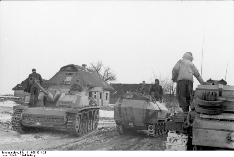 German StuG III assault gun and SdKfz. 251 halftrack vehicle in a Russian village, Jan 1944