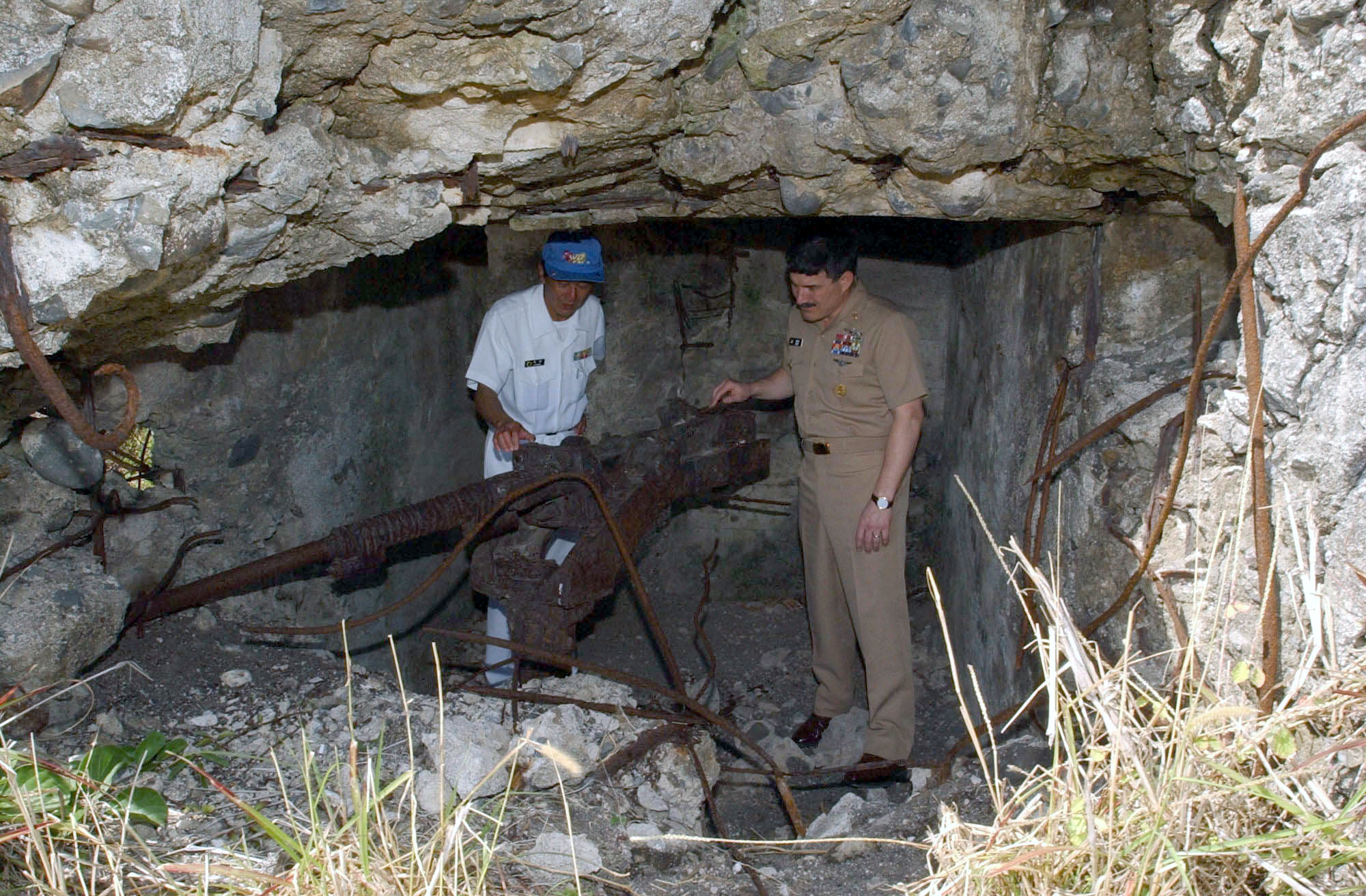 US Navy Master Chief Petty Officer Terry Scott inspecting an old Japanese Type 96 25mm gun at Iwo Jima, Japan, 23 Mar 2003