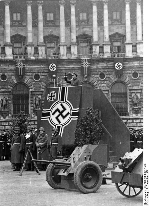 German Army General Werner Kienitz speaking to recruits at the Heldenplatz in Vienna, Austria, 9 Dec 1938; note 7.5 le.IG 18 infantry guns on display