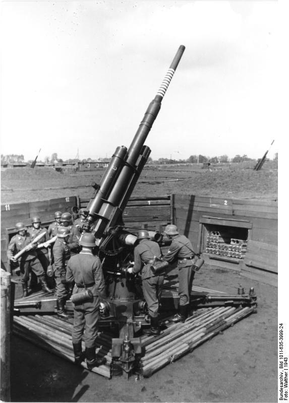 German Luftwaffe soldiers loading an 8.8 cm FlaK gun, Germany, 1943; note others guns in this battery in background