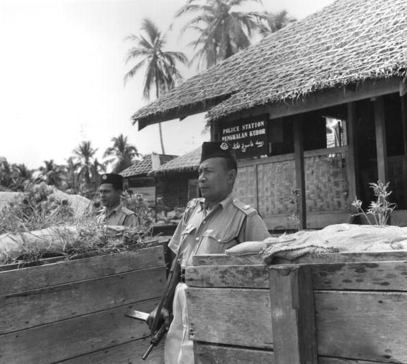 Malayan policeman with Sten gun at the police station in Pengkalan Kubor, Malaya, 22 Jul 1950